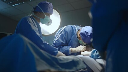 Team professional surgeons and nurses in uniform at work in operating room,performing heart transplant surgery operation under bright lamps and looking at screen.Teamwork surgeon in operating room - Powered by Adobe