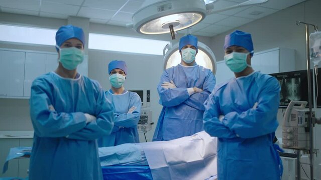 Team professional surgeons and nurses in uniform at work in operating room,performing heart transplant surgery operation under bright lamps and looking at screen.Teamwork surgeon in operating room