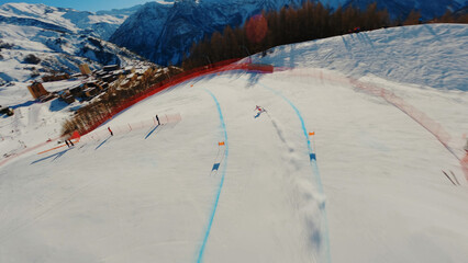 In this video, a FPV drone gracefully hovers above the trajectory of an alpine ski racer during the European Alpine Skiing Cup, capturing the skier's high-speed turn.