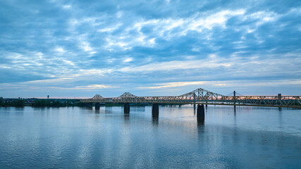 Obraz na płótnie Canvas Indiana side Louisville KY aerial Ohio River bridges over water under blue and yellow clouds