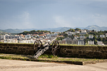 Antique cannon artillery defensive weapon on wall of cultural historic fort building Castillo de la Mota on Mount Urguell in front of bahia de la concha Donosita-San Sebastian Spain. 