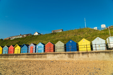 Colourful beach huts on the beach in Mundesley, North Norfolk, UK on a summer morning