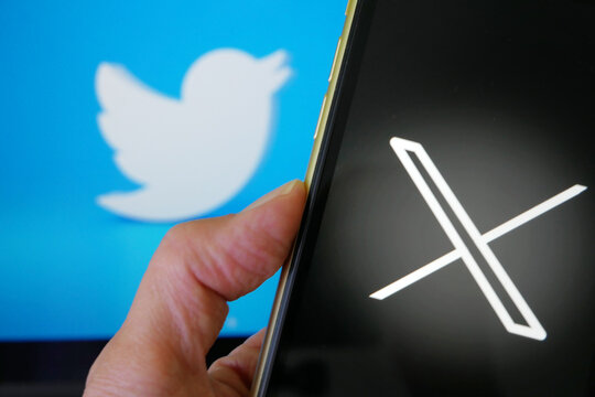 Lviv Ukraine  -  23 07 23: mobile phone with new logo X for twitter on blue background with white bird, Elon Musk vows to ditch bird logo