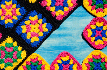 Fototapeta na wymiar Colorful cotton granny square. Crochet texture close up photo. Place for text.