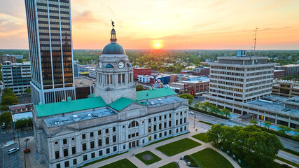 Sunrise on horizon in golden aerial of close up of downtown Fort Wayne courthouse - obrazy, fototapety, plakaty