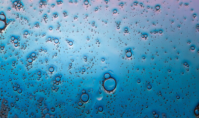 small air bubbles in water, with bright reflection on the light blue background
