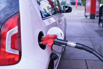 automobile refueling with a gasoline nozzle and hose
