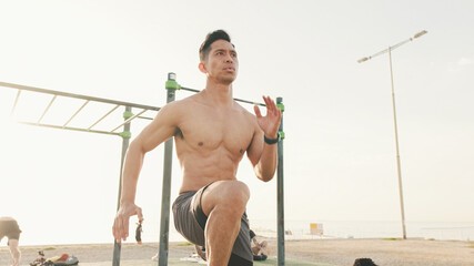 Guy athlete does a warm-up, training the leg muscles, run high raising your knees on an outdoor...