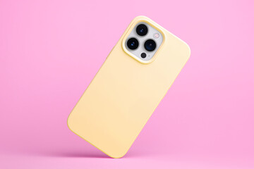 iPhone 15 Pro in yellow soft silicone case falls down back view, phone case mockup isolated on pink...