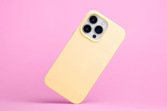 IPhone 15 Pro In Yellow Soft Silicone Case Falls Down Back View, Phone Case Mockup Isolated On Pink Background