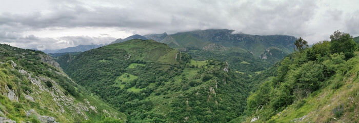 Naklejka na ściany i meble Panoramic view at the Picos de Europa, or Peaks of Europe, a mountain range extending for about 20 km, forming part of the Cantabrian Mountains in northern Spain