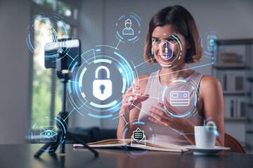 Happy woman is making video blog using smartphone on a tripod explaining with hands at office workplace. Concept of online stream, business education, conference call. Lock icons hologram