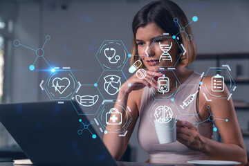 Thoughtful businesswoman in casual wear typing on laptop at office workplace with coffee cup. Concept of distant work, business, internet surfing, information technology. Medical icons hologram