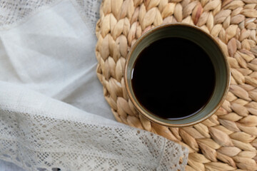 a cup of coffee on a straw napkin