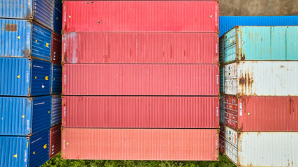Overhead downward view of pink pastel colored shipping containers in shipping yard aerial