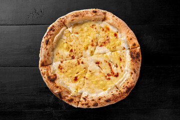 Cheese pizza with browned edge on black wooden background