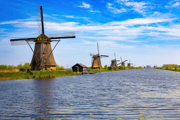 Fototapeta premium Prespective view of the canal and five windmills on its slope that preside over it. KInderdijk, The Netherlands