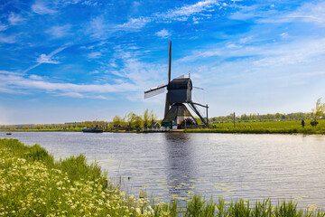 Prespective view of the canal where on the other bank is dominated by a huge windmill, the only one...