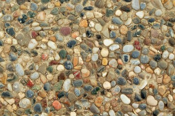 Background, texture of a footpath decorated with multi-colored sea pebbles