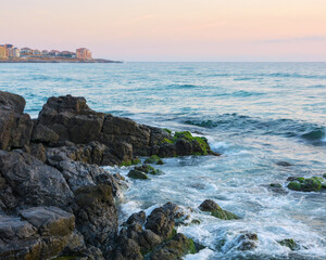 Fototapeta na wymiar rocks on the seaside of resort town. beautiful leisure scenery in summertime at sunrise