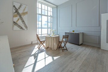 romantic table is served for two in the kitchen in a bright open-plan apartment in a modern style...