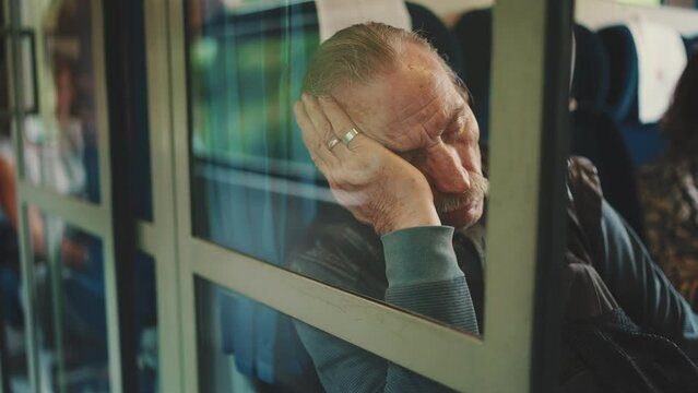 Closeup of senior sleeping while traveling in train coupe, view through coupe glass
