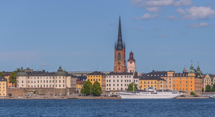 Fototapeta na wymiar Old steel boat hotel at the pier Evert Taubes terass, court houses and churches in at the island Riddarholmen, a sunny summer day in Stockholm
