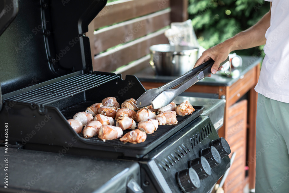 Wall mural man cooking meat on barbecue grill. close-up of delicious meal