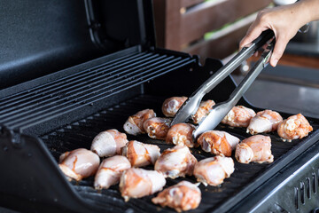 Man cooking meat on barbecue grill. Close-up of delicious meal