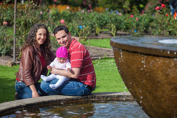 Young parents having fun outdoors with their six months old baby girl. Happiness concept. Family concept