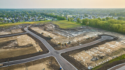 Housing construction aerial bulldozer, bobcat cul-de-sac with paved road distant houses neighborhood