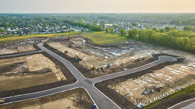 Housing construction aerial bulldozer, bobcat cul-de-sac with paved road distant houses neighborhood