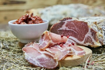 Dried or smoked sausage on a wooden table surrounded by spices and products. Meat production.
