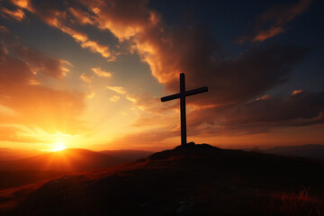 Silhouette of crucifix on hill against vivid sunset sky colors