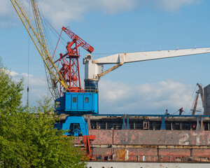 shipbuilding cranes in the repair port there is a ship under repair nearby