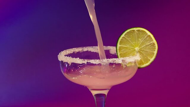 barbie cocktail. barbie core. Professional barman decorates a blue cocktail with ice . Bartender prepares cocktails on defocused background and pours and serves a cocktail . Barman preparing colorful