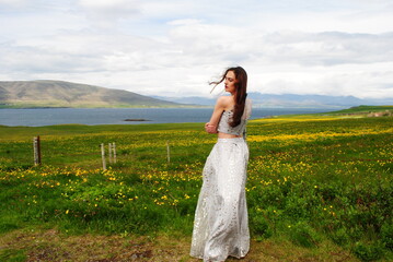 A woman stands near a field in Mossfellsbaer, Iceland.