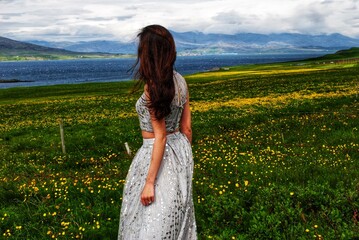 A woman stands near a field in Mossfellsbaer, Iceland.