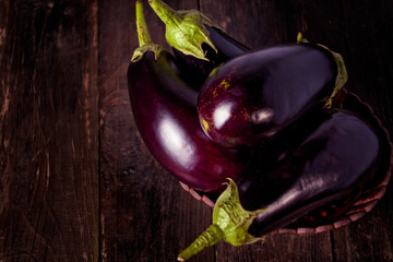 Close-up Several Eggplants On A Wooden Table in a Wooden Basket
