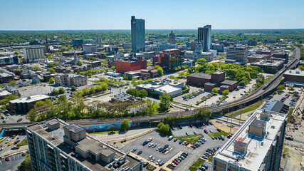 Cityscape downtown Fort Wayne IN with train tracks and train bridge skyscraper and trees in background