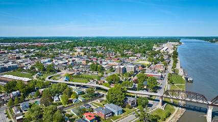 Aerial over ohio river iron arch bridge suspense highway cutting through town city Kentucky - obrazy, fototapety, plakaty