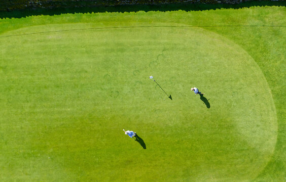 Golf course green aerial view and two players