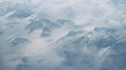 Aerial view of white snowy mountains with blue and cloudy sky