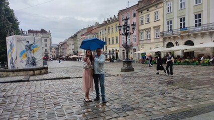 couple under an umbrella on the square of the city of Lviv Ukraine