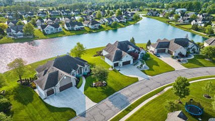 Large houses next to pond view and trampoline neighborhood aerial - obrazy, fototapety, plakaty