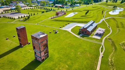 Aerial of lush green grass at Ariel Foundation Park and its factory building remains