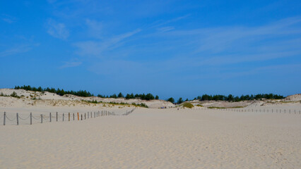 Moving dunes in the Slovincian National Park also known as Slowinski National Park. Landscape with beautiful sand dunes touristic trail and the Baltic Sea, Leba. Poland
