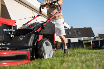 woman mowing lawn in garden