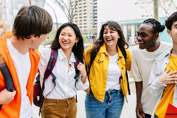 Multiracial group of happy students laughing and having fun together at college campus