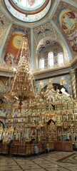man near the cdome of the Pochaevsky Cathedral with a huge golden chandelier against the background of iconsathedral Pochaev Monastery Ukraine